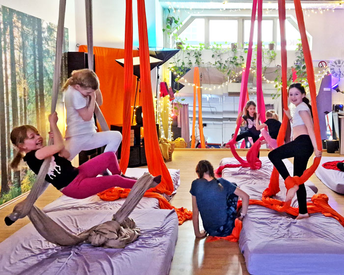 Volkschulkinder machen verschiedene Figuren am Aerial Silk im Aerial Jungle Poysdorf, Niederösterreich